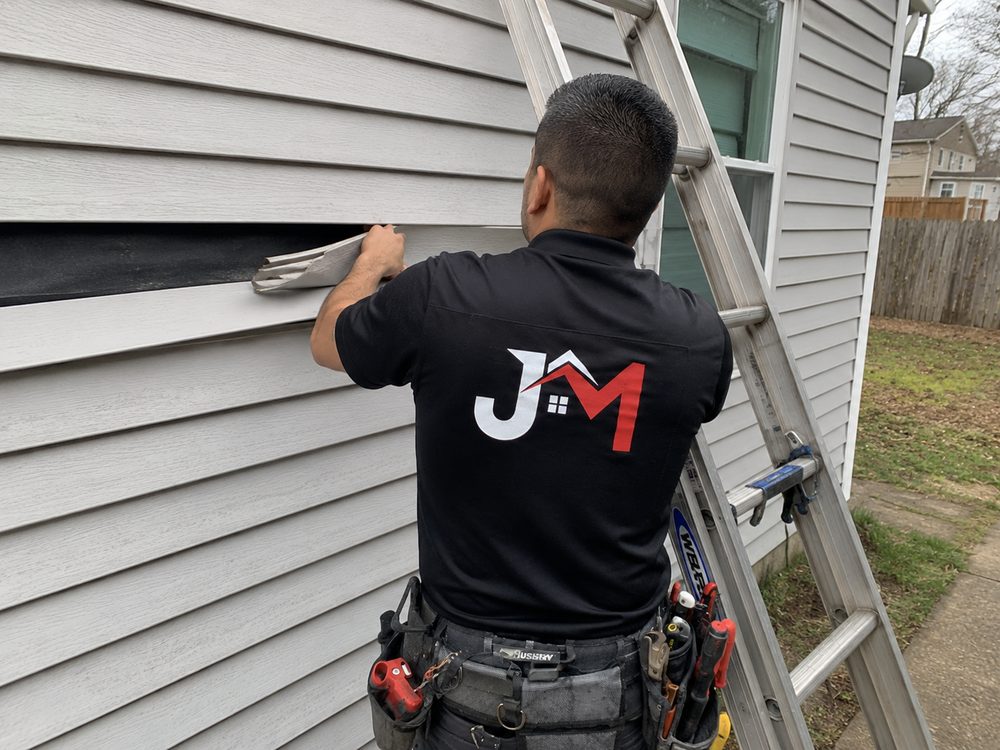 J&M technician performing exterior siding maintenance