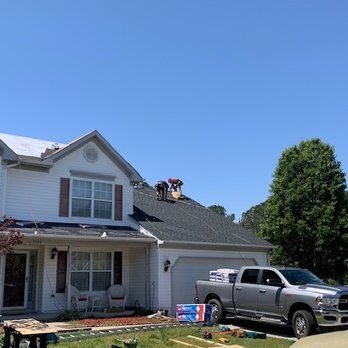 Crew working on two-story home roof